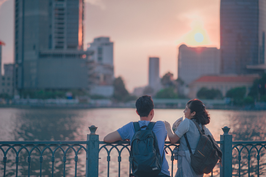 Couple Having Conversion Near Metal Fence during Golden Hour
